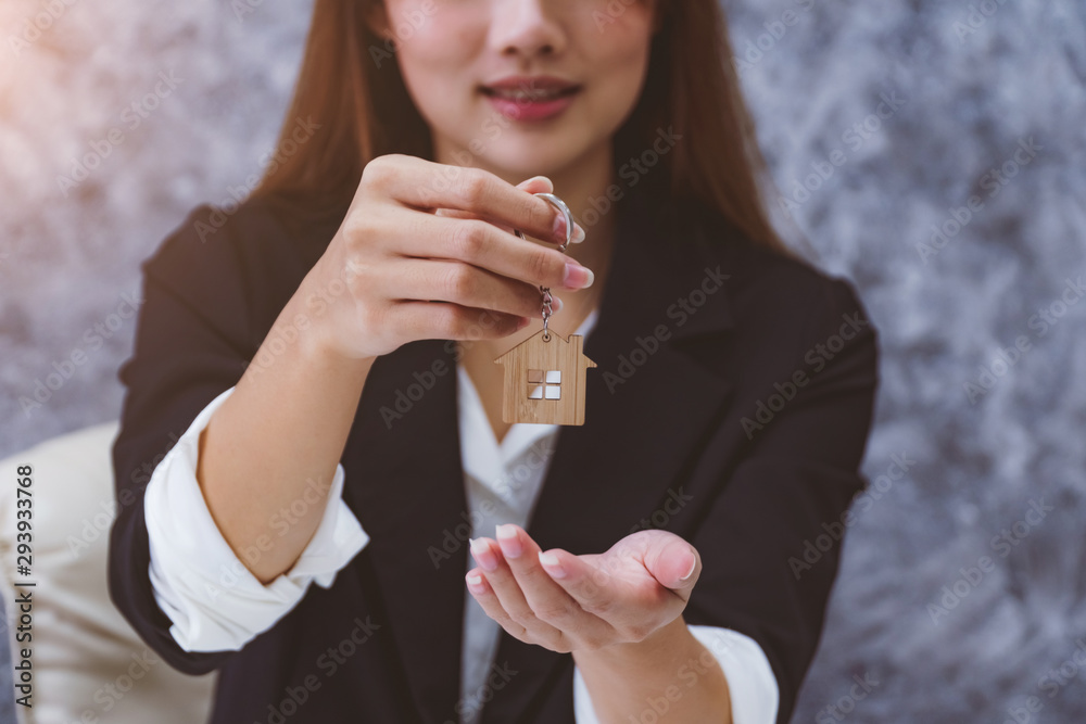 Φωτογραφία Hands of a woman showing key from female real estate agent for rental lease contract or sale purchase agreement