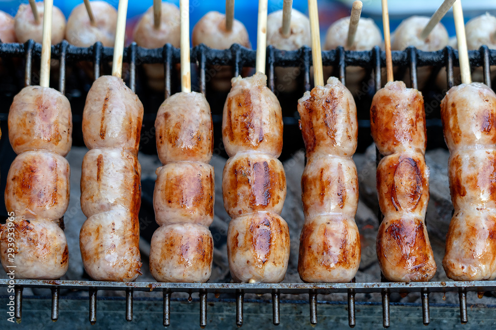 Grilled Thai sausage at street food market in Thailand, closeup. Traditional Thai sausage with pork and rice, delicious street food