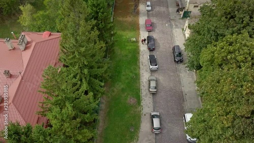 Aerial view of couple walking on street and camera tilt up to the Lviv landscape