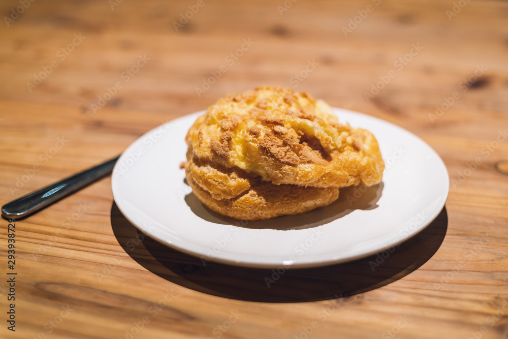 Freshly baked Vanilla Choux Cream Puff on white plate with fork. Freshly baked Vanilla Choux Cream Puff on white plate with fork.