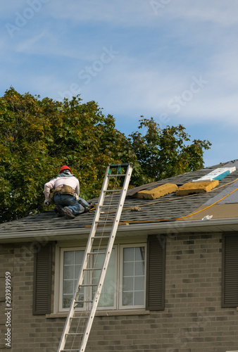 Two workers surveying a damaged roof