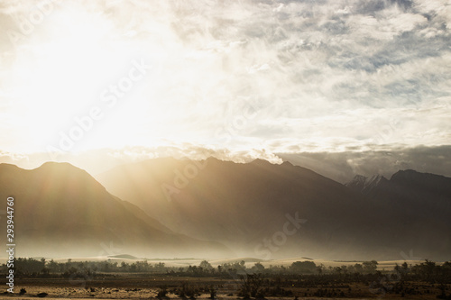 Stunning light and beautiful mist on sunrise background at Nubra valley, Leh Ladakh, India. Scence of light with lens flare. photo