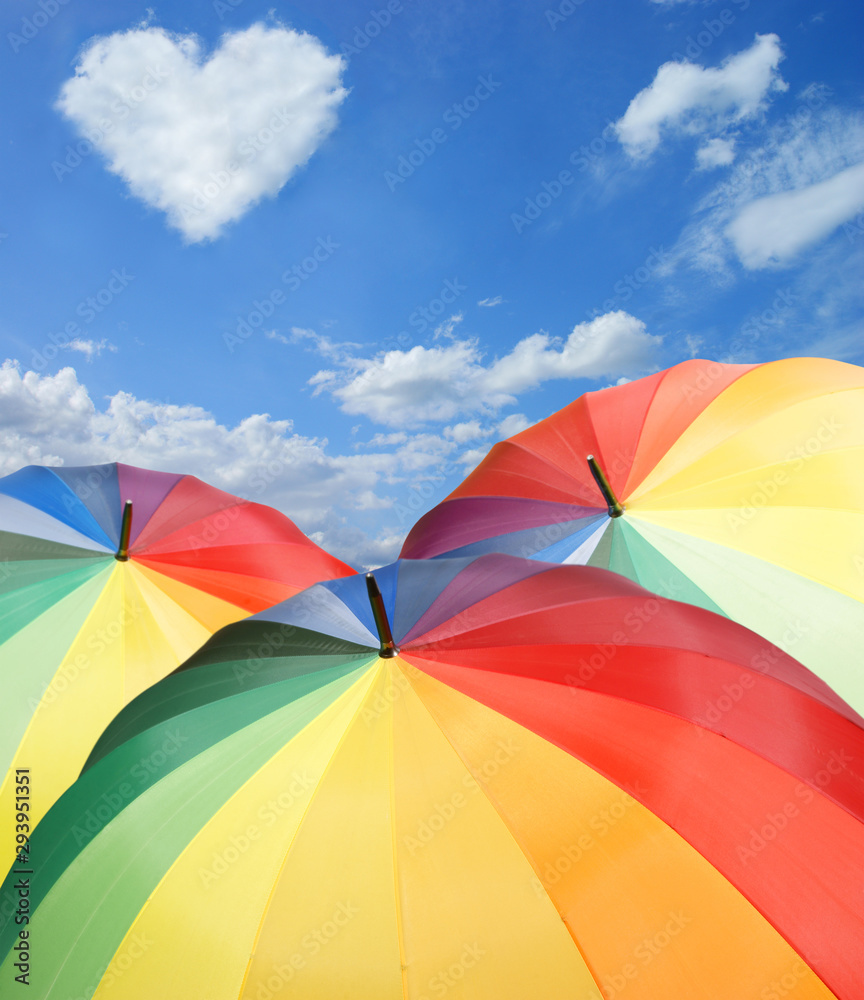 Rainbow umbrellas on blue sky background