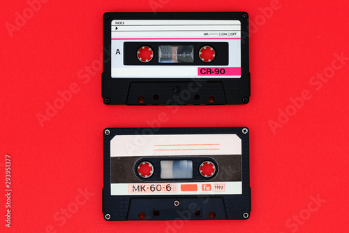 Two old audio cassettes on a bright red background. Top view  old technology concept