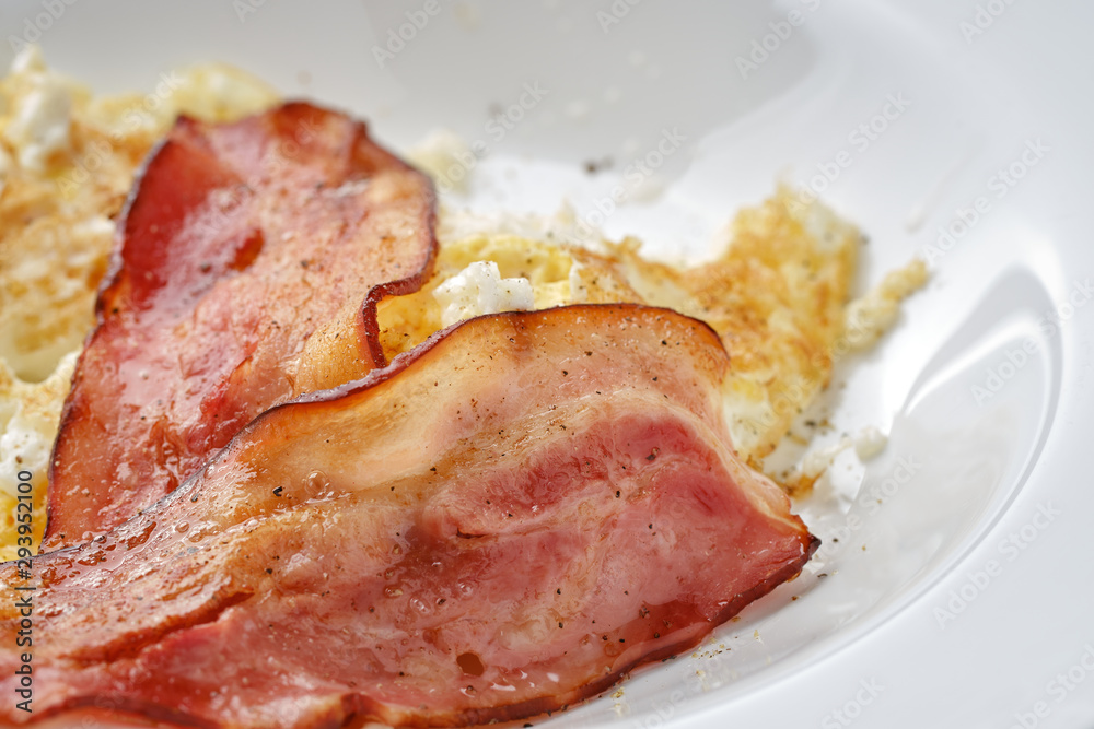 fried bacon and eggs on breakfast close up
