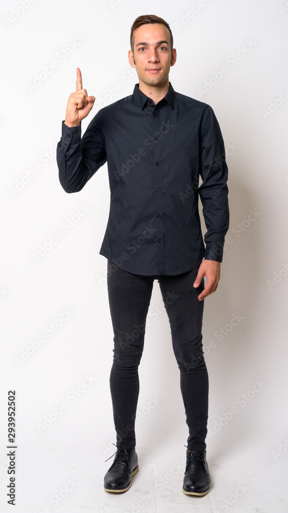 Full body shot of young Persian businessman pointing up Full body shot of young Persian businessman pointing up
