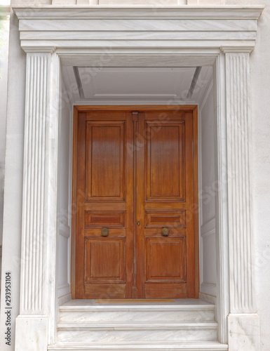 contemporary elegant house entrance solid wood door and white marble walls © Dimitrios