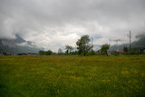 Beautiful scene of fresh field in small village at rural area of switzerland on cloudy sky background with copy space
