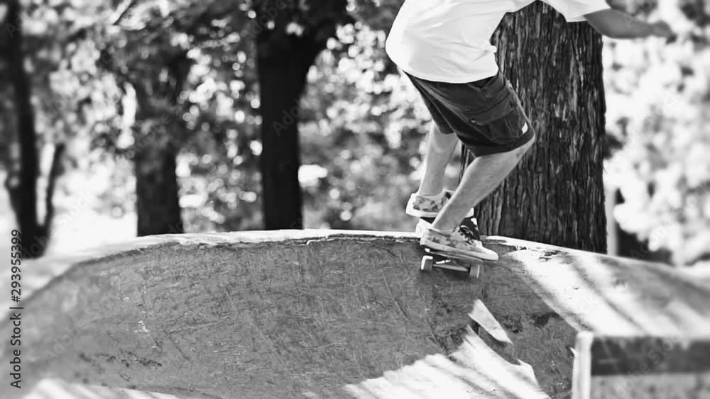 Skateboarder in slow motion making trick on ramp in a skateboard park in black and white color