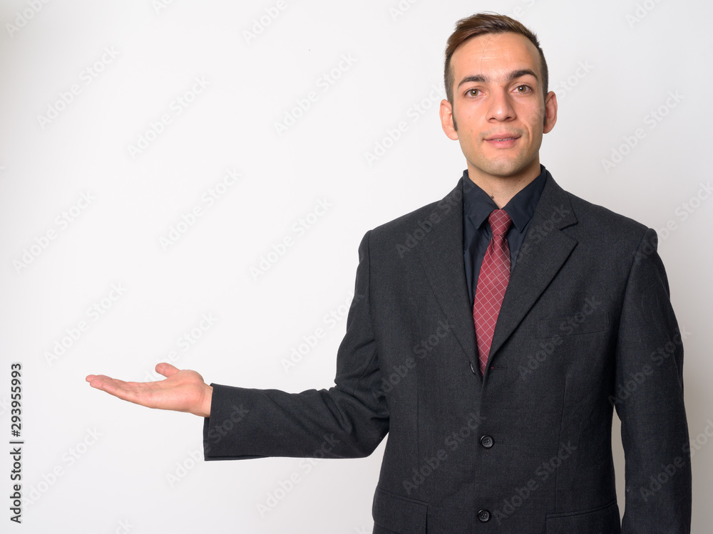 Young Persian businessman in suit showing something Young Persian businessman in suit showing something