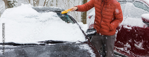 The guy cleans the car from the snow with a brush, Bad snow weather concept
