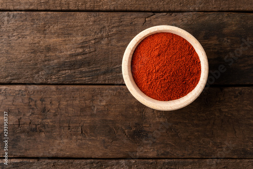 Slika na platnu Dried red paprika powder in bowl on retro wooden background