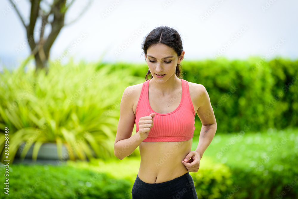 Fototapeta premium Beautiful woman runner has to warm up in the garden.