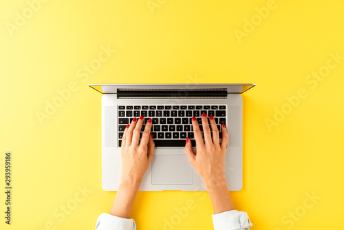 Woman’s hands working on laptop. Modern office desktop with copyspace. Top view