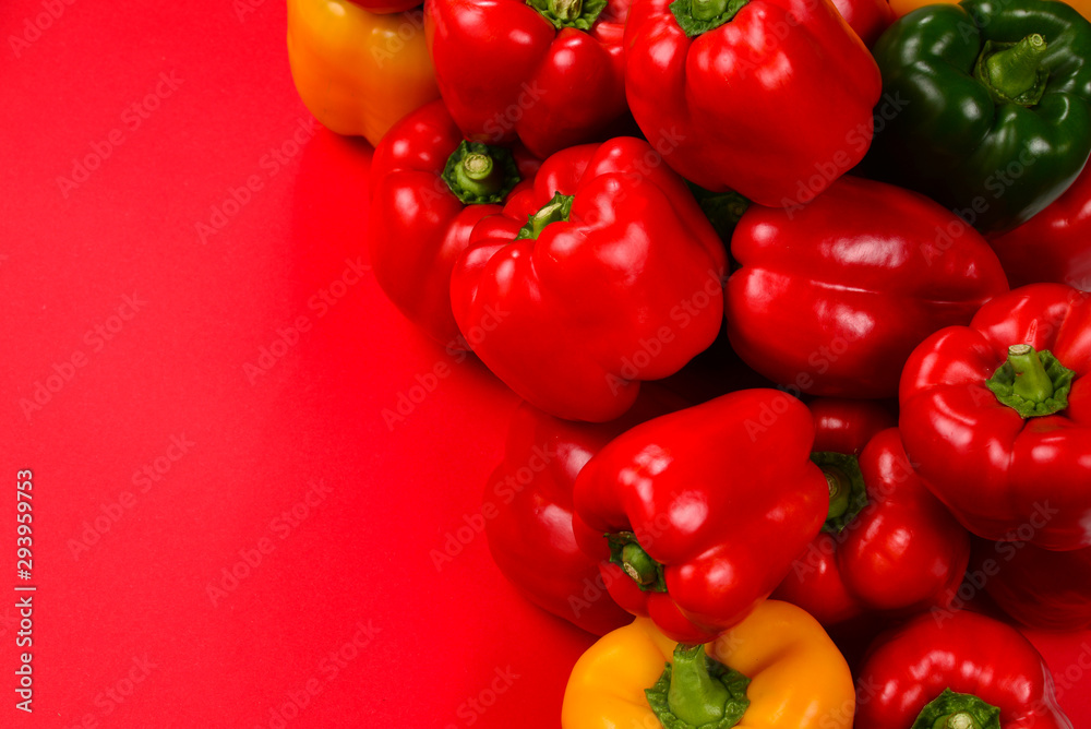 Fresh red, yelow, green bell pepper on a red background. Fresh red, yelow, green bell pepper on a red background.