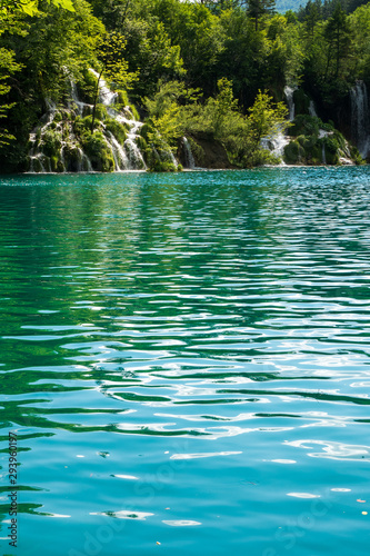 Rushing water cascades down the natural barriers into the crystal clear and azure coloured Lake Milanovac at the Plitvice Lakes National Park, Croatia