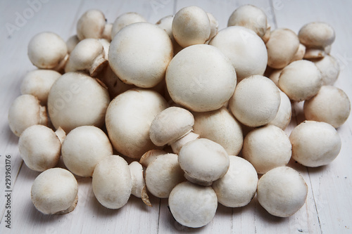 Champignon mushrooms on a white wooden background