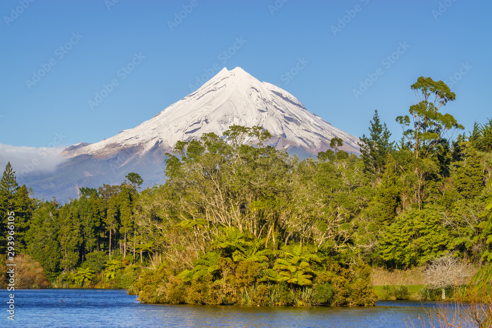 Snow covered Mount Taranaki viewed from Lake Mangamahoe. Also known as Mount Egmont this dormant volcano is located in the Taranaki District of the North Island of New Zealand. Snow covered Mount Taranaki viewed from Lake Mangamahoe. Also known as Mount Egmont this dormant volcano is located in the Taranaki District of the North Island of New Zealand.