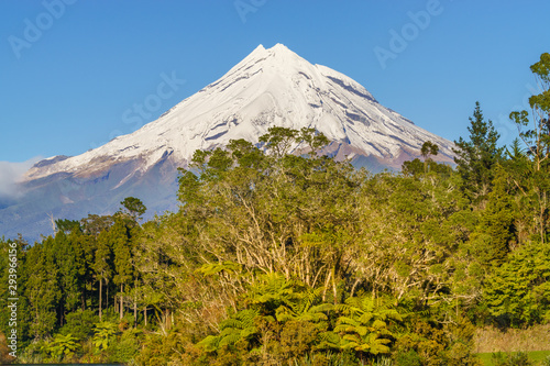 Snow covered Mount Taranaki viewed from Lake Mangamahoe. Also known as Mount Egmont this dormant volcano is located in the Taranaki District of the North Island of New Zealand.
