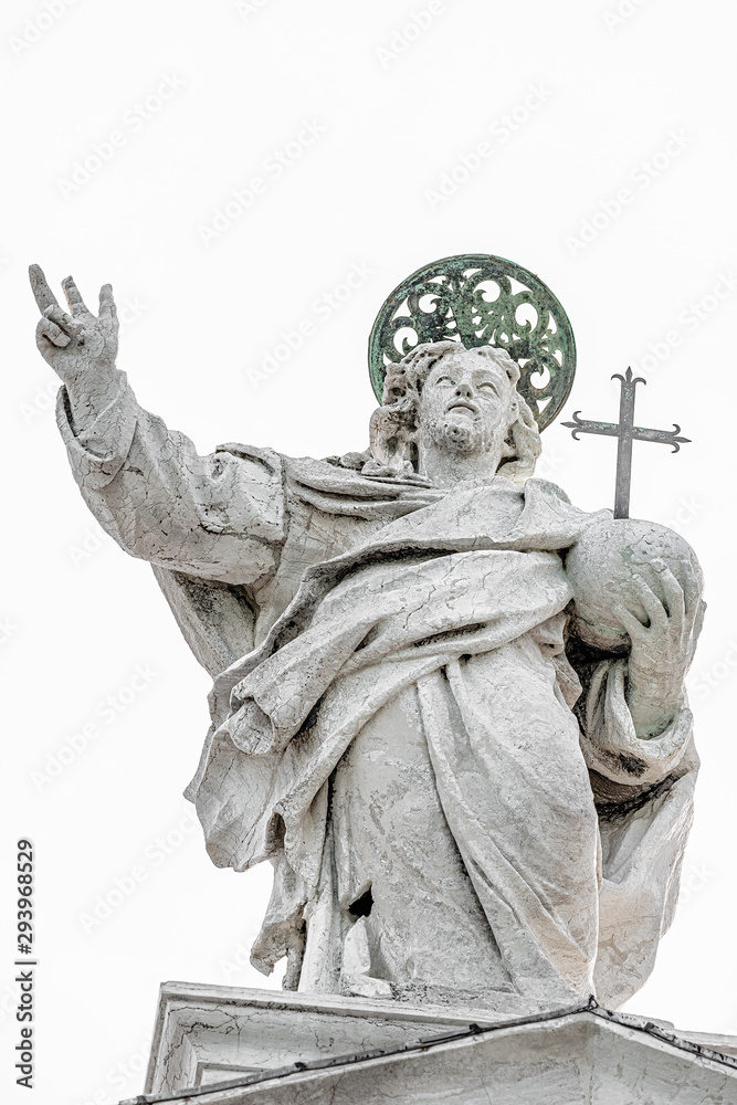 Fototapeta premium Holly priest with cross and nimbus at the roof of Church of San Giorgio Maggiore in Venice isolated at white background, Italy