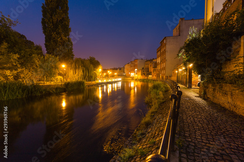 Bydgoszcz in Poland. Night view. Picturesque channels of the Brda River flowing through the city center. Old historic factory and residential buildings stand along the river