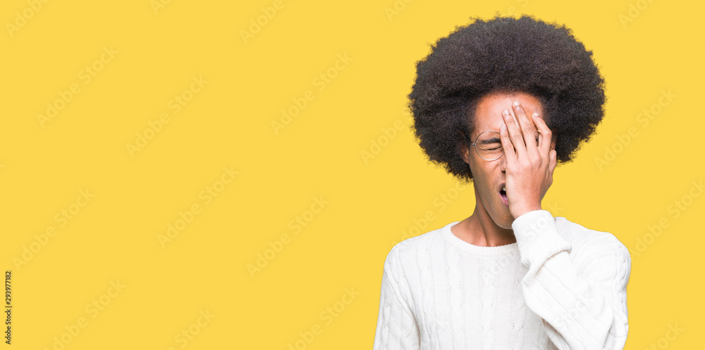 Young african american man with afro hair wearing glasses Yawning tired covering half face, eye and mouth with hand. Face hurts in pain. Young african american man with afro hair wearing glasses Yawning tired covering half face, eye and mouth with hand. Face hurts in pain.