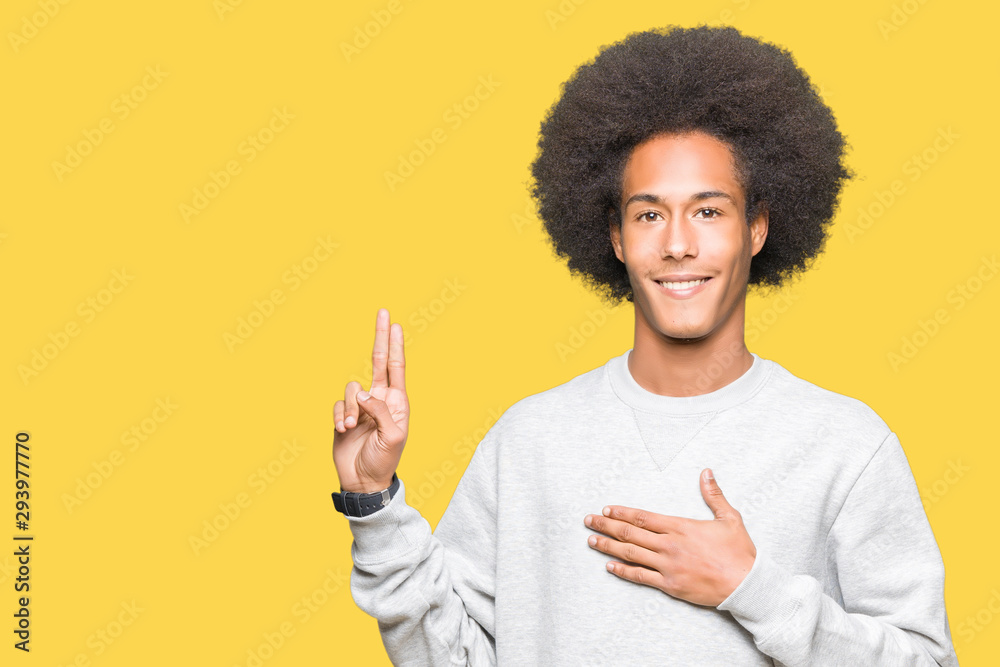 Young african american man with afro hair wearing sporty sweatshirt Swearing with hand on chest and fingers, making a loyalty promise oath Young african american man with afro hair wearing sporty sweatshirt Swearing with hand on chest and fingers, making a loyalty promise oath