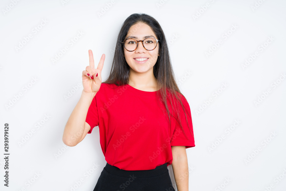 Beautiful brunette woman wearing glasses over isolated background smiling with happy face winking at the camera doing victory sign. Number two. Beautiful brunette woman wearing glasses over isolated background smiling with happy face winking at the camera doing victory sign. Number two.