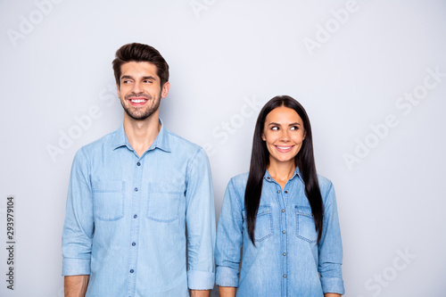 Photo of cute cheerful brown haired charming couple of spouses feeling awkward smiling toothily wearing jeans denim isolated over grey color background