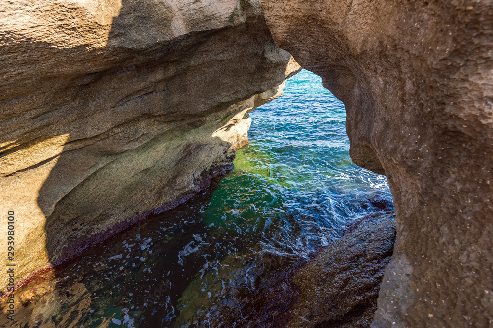 Coastal stone arch with azure clean water