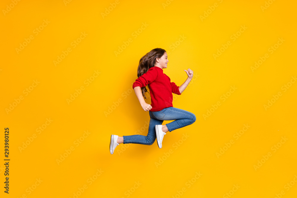 Full length profile side photo of positive cheerful brunette wavy curly hair kid jump run fast speedy after winter season discounts wear style clothes white sneakers isolated yellow color background
