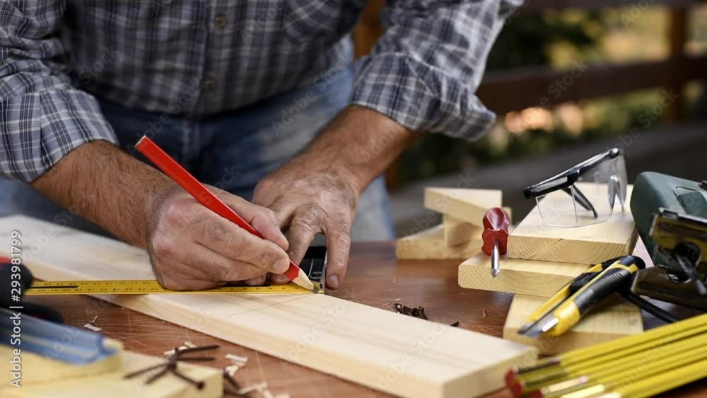 Adult carpenter craftsman with a pencil and the carpenter's square trace the cutting line on a wooden table. Construction industry, housework do it yourself. Footage. Adult carpenter craftsman with a pencil and the carpenter's square trace the cutting line on a wooden table. Construction industry, housework do it yourself. Footage.