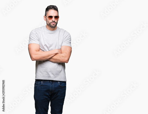 Young handsome man wearing sunglasses over isolated background skeptic and nervous, disapproving expression on face with crossed arms. Negative person.