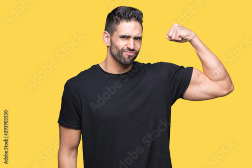 Young handsome man over isolated background Strong person showing arm muscle, confident and proud of power