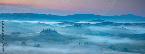 Tuscany Misty dawn over farmhouses, vineyards olive groves & trees of Val D'Orcia San Quirico south of Pienza Tuscany Italy photo