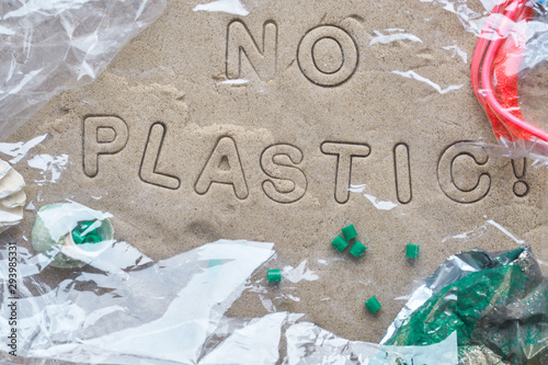 No plastic text on sand framed with various debris and covered with transparent film photo