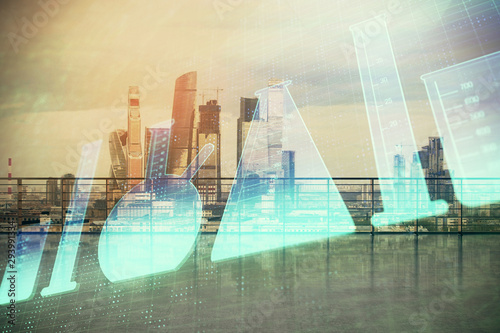 Laboratoy flask hologram with city view from roof top background. Double exposure. Study concept.