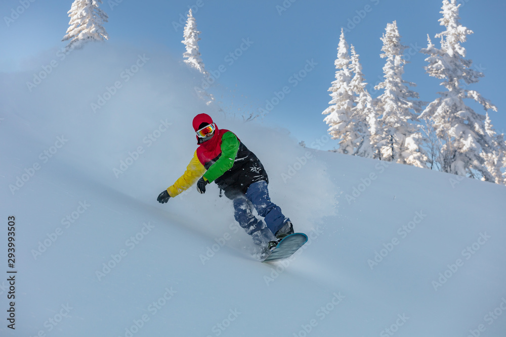 guy in a bright suit rides a snowboard in the snowy mountains. Snowboarding sport photo. Snowboarder in action on the track with fresh snow. very high resolution and photo quality