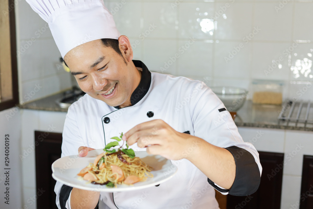 Asian Man Chef cooking food in restuarant Asian Man Chef cooking food in restuarant
