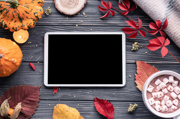Autumn fall holiday background with pumpkin orange leaves cocoa cup tablet computer blank empty screen mock up on brown wooden table, happy halloween thanksgiving shopping sale, above top view
