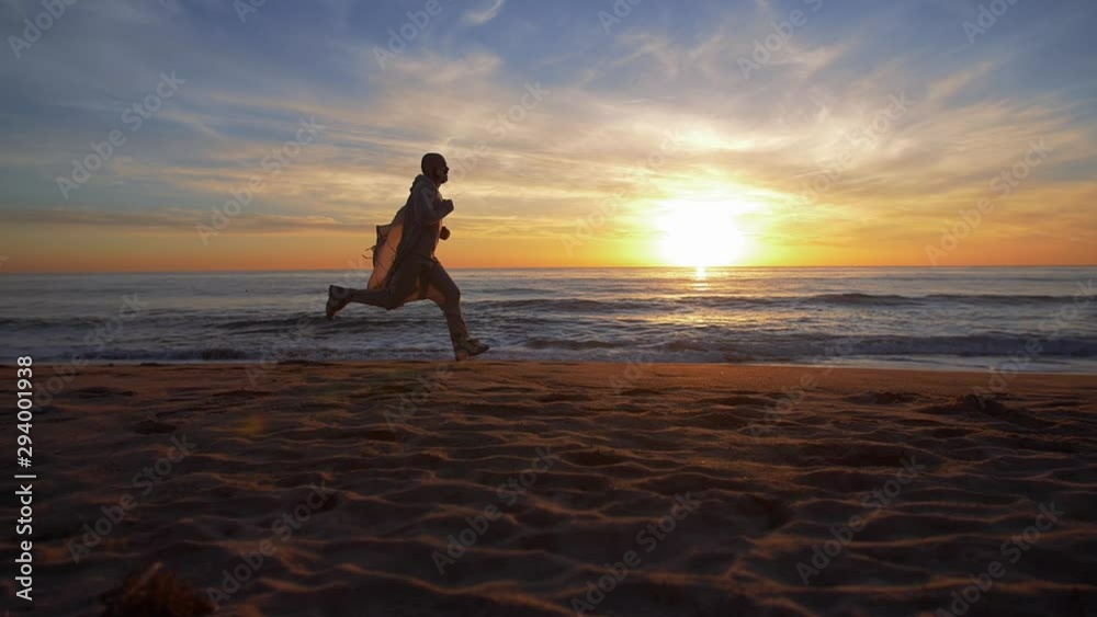 Man runs on LA beach at sunset. California, USA Man runs on LA beach at sunset. California, USA