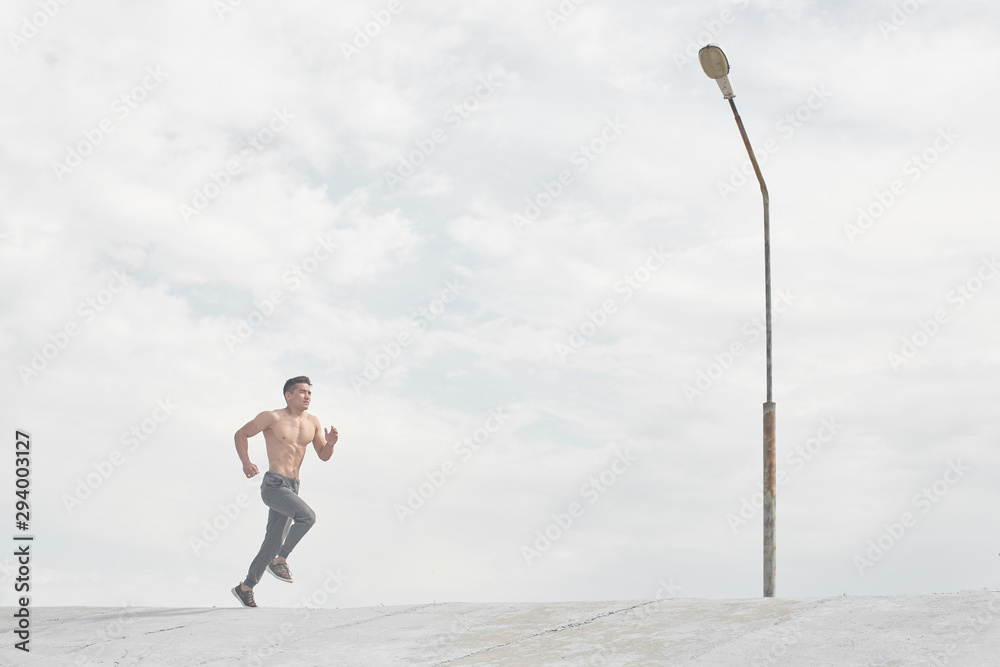 Asian athlete man jogging in the morning outdoors, Kazakh runner minimalism photo style Asian athlete man jogging in the morning outdoors, Kazakh runner minimalism photo style
