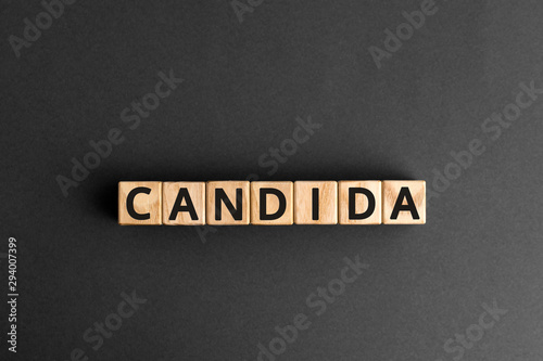 Candida - word from wooden blocks with letters, a parasitic fungus candida concept, grey background