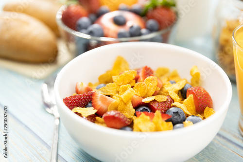 Healthy breakfast. bread, orange juice, strawberry, blueberries, milk and cereal in bowl on wooden table. Healthy food