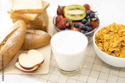 Fototapeta Naklejka Na Ścianę i Meble -  Healthy breakfast. bread, strawberry, blueberries, kiwi, milk and cereal in bowl on mat background. Healthy food