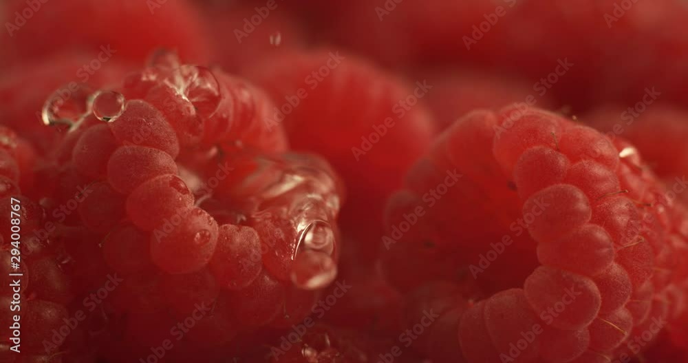 Water dripping onto raspberry in super slow motion