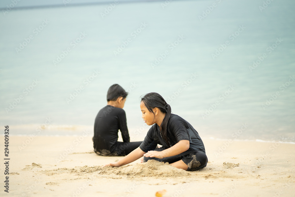 Young asian kids are playing on the beach. Vacation and relax concept.