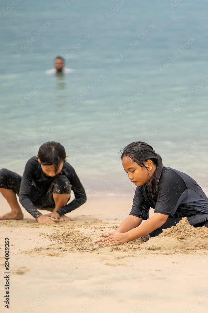 Fototapeta premium Young asian kids are playing on the beach. Vacation and relax concept.