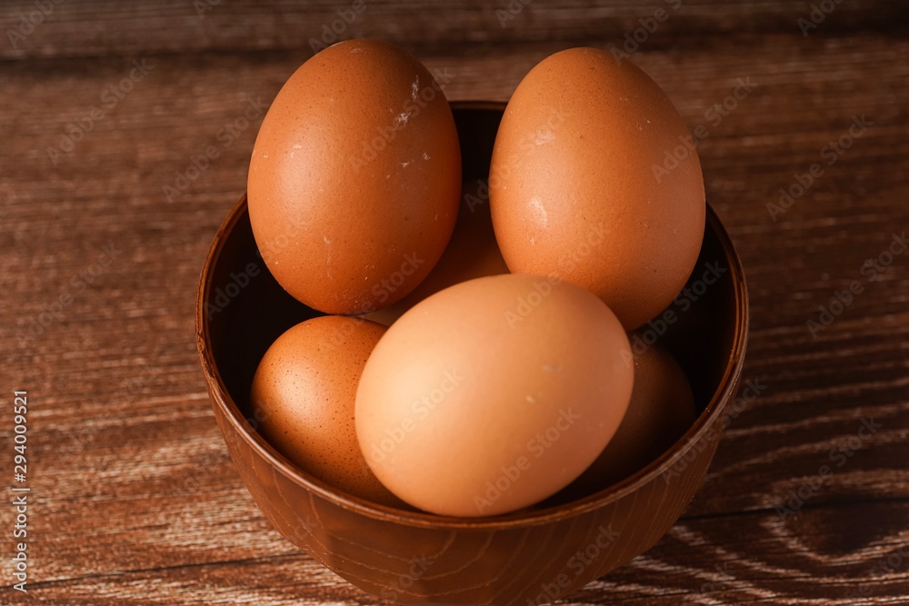 A carton of eggs on a wooden background A carton of eggs on a wooden background