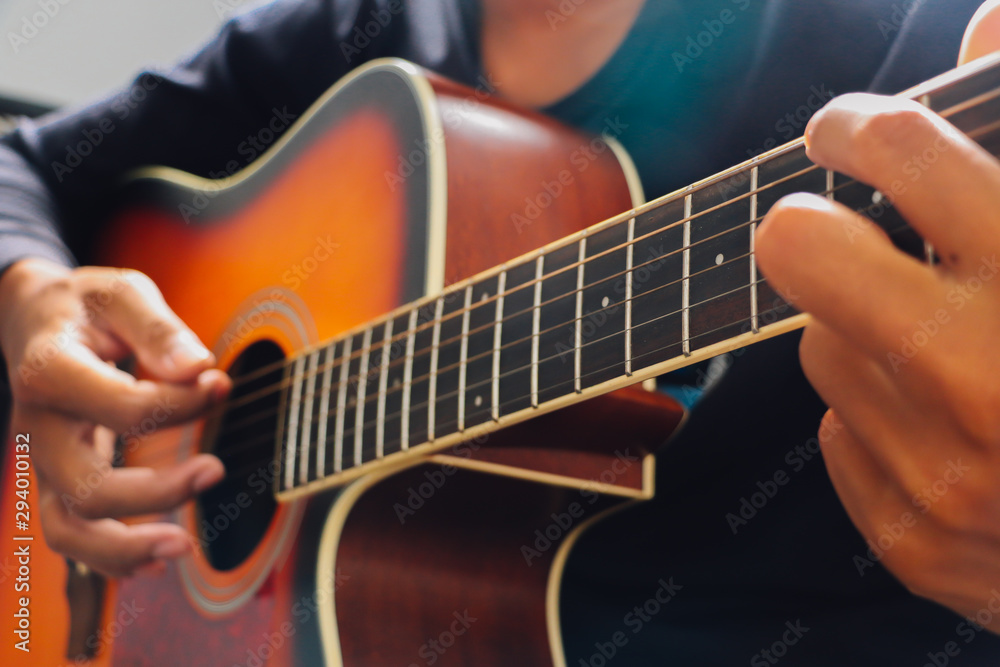 Obraz premium Man's hand playing acoustic guitar, close up
